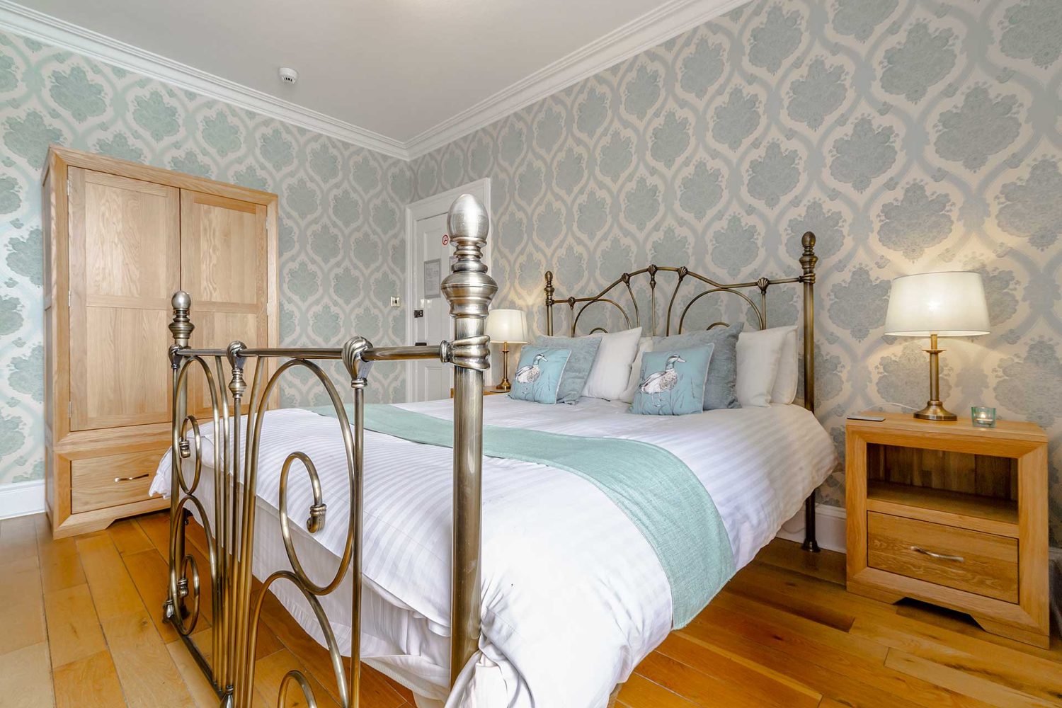 Large double bed in light green themed room